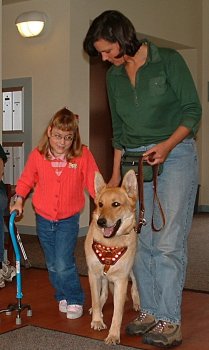 girl and dog trainer walking together with therapy dog
