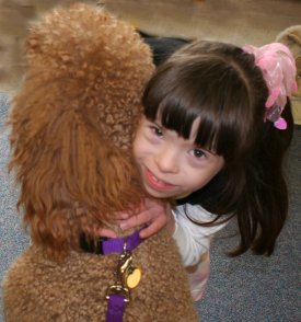 Cute child with special needs hugging a therapy dog.